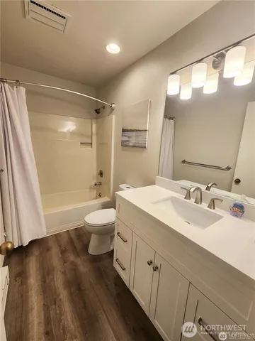 a spacious bathroom with a double vanity sink toilet mirror and shower