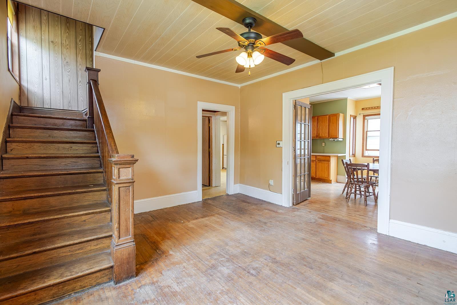 438 9th Street Cloquet, MN 55720 - Photo 8 of 27 Hardwood staircase and flooring with a painted beadboard ceiling and ceiling fan