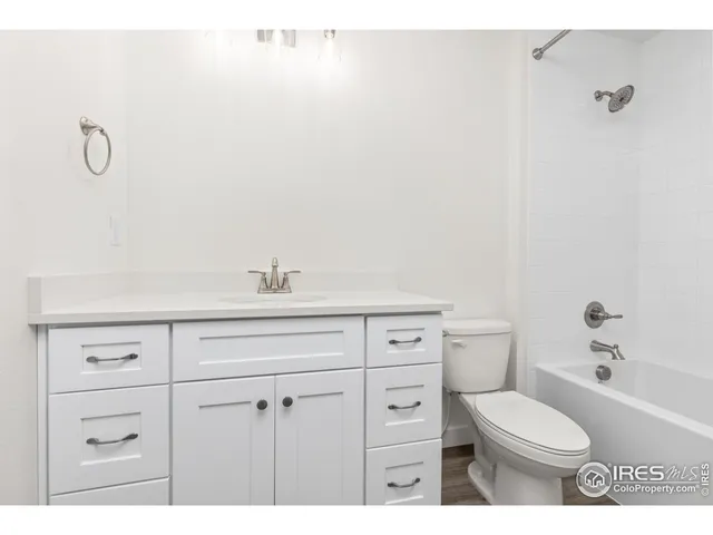 a bathroom with a toilet sink vanity and tub