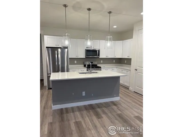 a kitchen with kitchen island a sink stainless steel appliances and cabinets