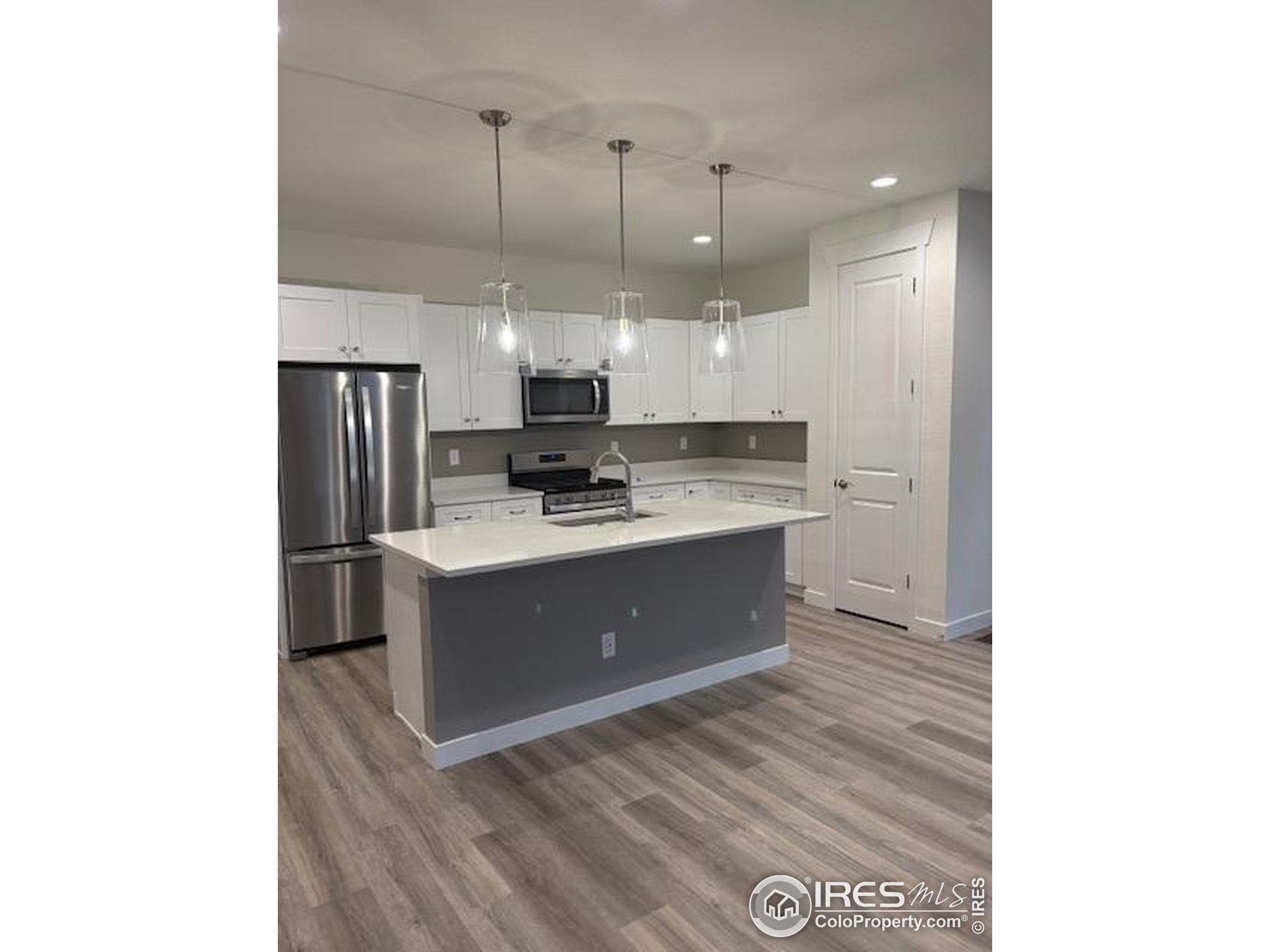 161 Washington Street Erie, CO 80516 - Photo 5 of 19 a kitchen with kitchen island cabinets and stainless steel appliances