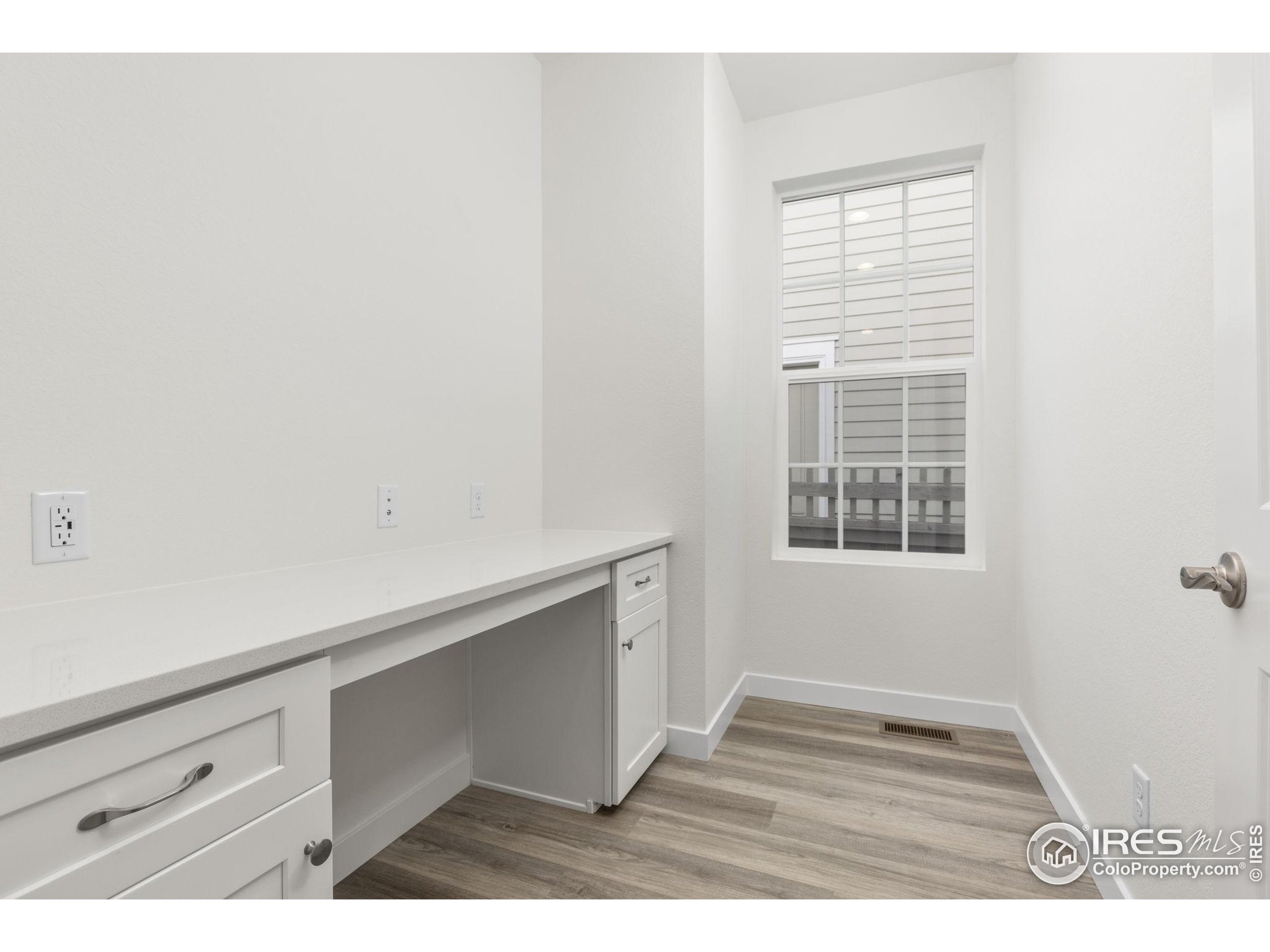 161 Washington Street Erie, CO 80516 - Photo 8 of 19 a view of an empty room with wooden floor and a window