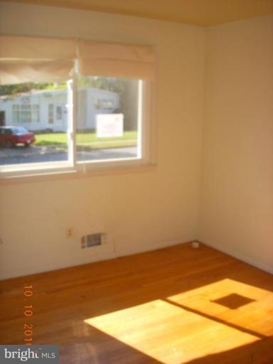 8518 Stevenswood Road Windsor Mill, MD 21244 - Photo 5 of 10 an empty room with wooden floor and windows