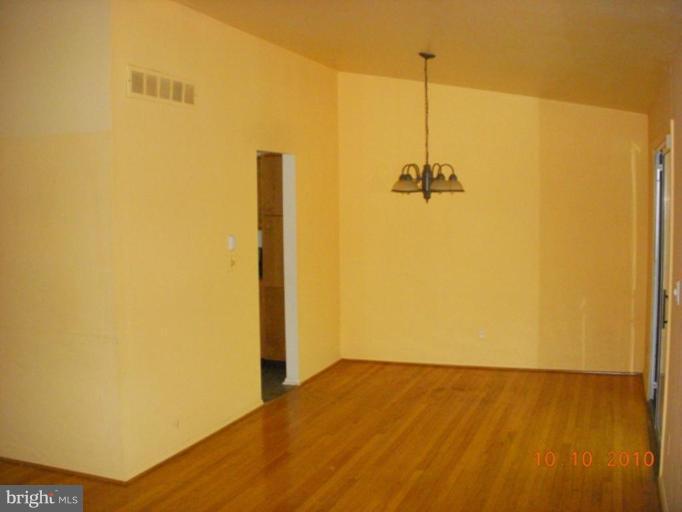 8518 Stevenswood Road Windsor Mill, MD 21244 - Photo 7 of 10 a view of a room with wooden floor and a ceiling fan