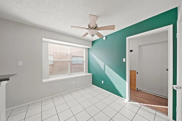 a view of an empty room with window closet and ceiling fan