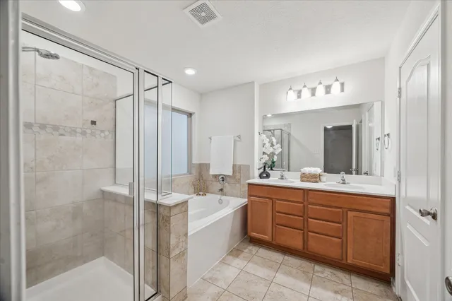 a bathroom with a double vanity sink mirror and shower