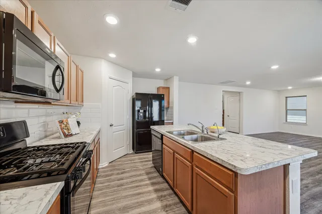 a kitchen with stainless steel appliances granite countertop a sink stove and refrigerator