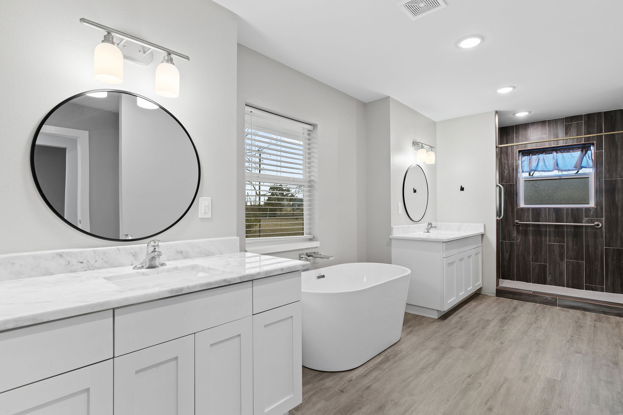 813 Central Avenue Elgin, TX 78621 - Photo 17 of 22 Bathroom featuring two vanities, a freestanding bath, a stall shower, light wood finished floors, and recessed lighting