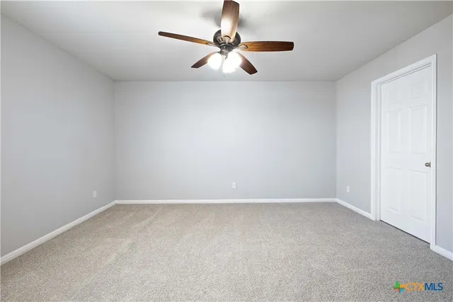 an empty room with closet and windows