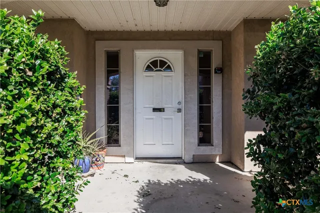 an entrance view of a house with trees