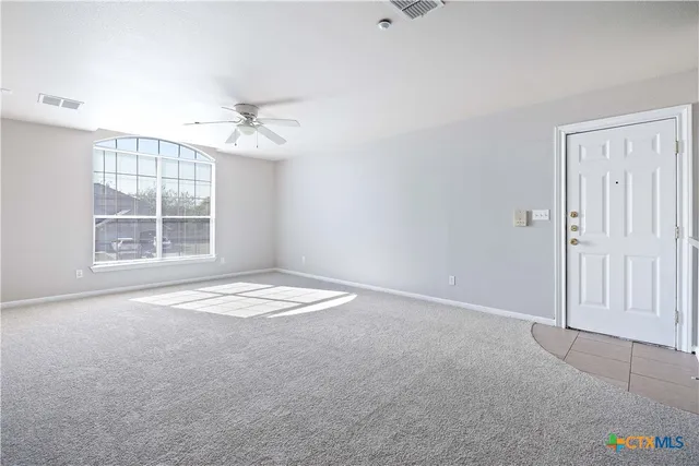 an empty room with windows and cabinet