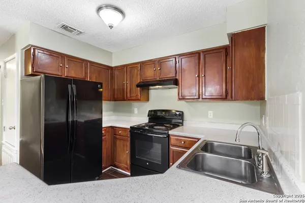 a kitchen with a refrigerator sink and cabinets