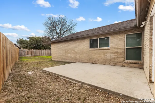 a view of a backyard with wooden fence