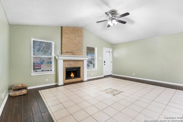 an empty room with windows and fireplace