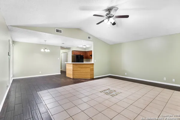 a view of a room with a ceiling fan and wooden floor