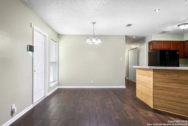 a view of a hallway with entryway wooden floor and cabinet