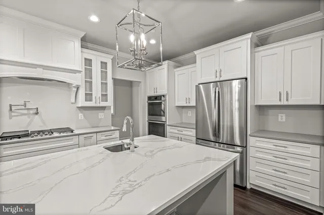 a kitchen with stainless steel appliances kitchen island granite countertop a refrigerator and microwave