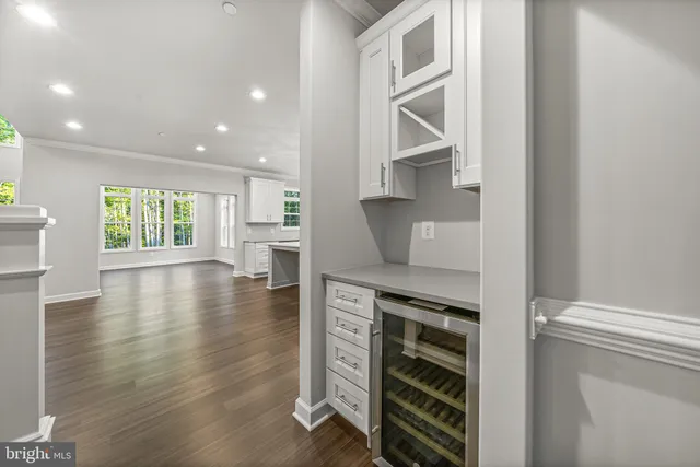 a kitchen with a white cabinets and wooden floor