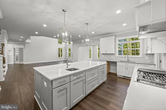 a large kitchen with kitchen island a sink stove and wooden floor