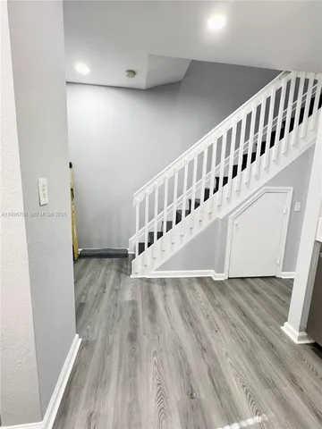 a view of a hallway with wooden floor and staircase