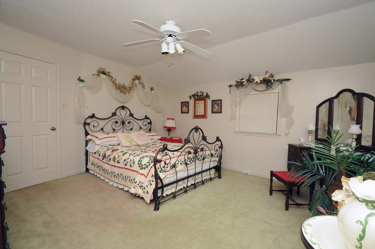 2375 Stanton Koko Road Stanton, TN 38069 - Photo 22 of 25 a spacious bedroom with a bed and a chandelier