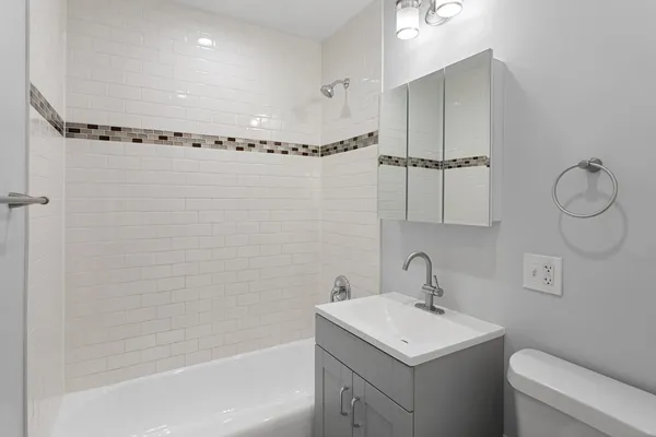 a bathroom with a sink a toilet and shower