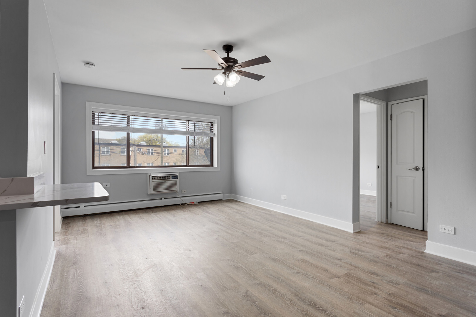 6826 North Ridge Boulevard, Unit 202 Chicago, IL 60645 - Photo 3 of 15 an empty room with wooden floor and windows