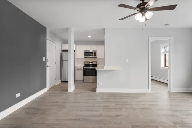 a view of a kitchen with a refrigerator and a ceiling fan