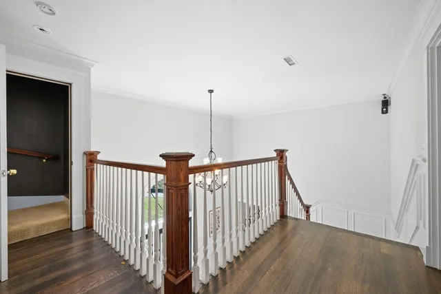 a view of a hallway with wooden floor and stairs