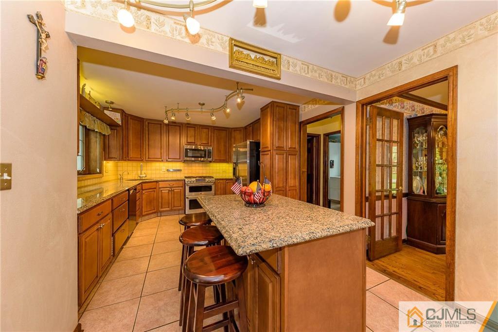 23 Covered Bridge Road Branchburg, NJ 08853 - Photo 6 of 25 a kitchen with stainless steel appliances granite countertop table chairs and a stove