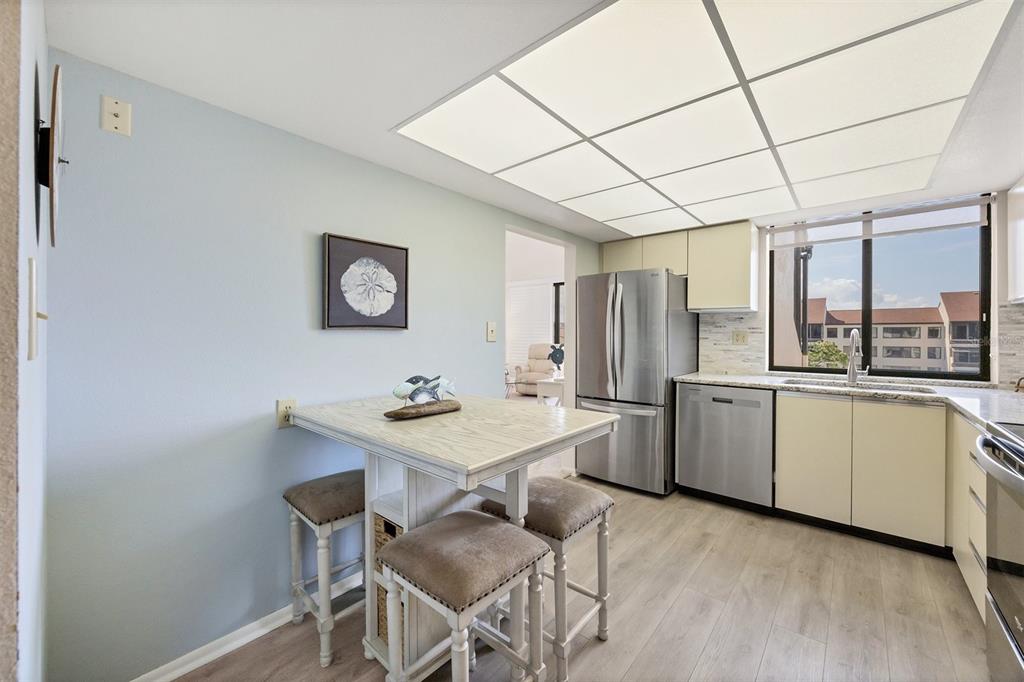 6285 Midnight Pass Road, Unit 403 Sarasota, FL 34242 - Photo 12 of 53 a kitchen with refrigerator and window