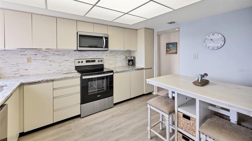 6285 Midnight Pass Road, Unit 403 Sarasota, FL 34242 - Photo 13 of 53 a kitchen with a stove a sink and a microwave