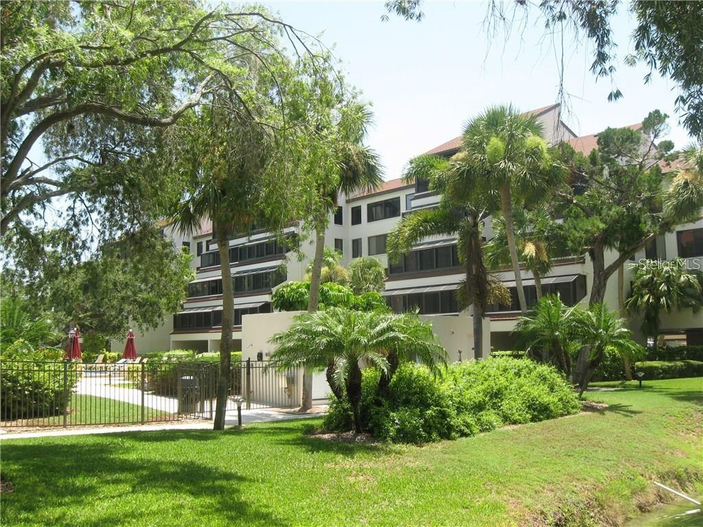 6285 Midnight Pass Road, Unit 403 Sarasota, FL 34242 - Photo 32 of 53 a front view of a house with a yard