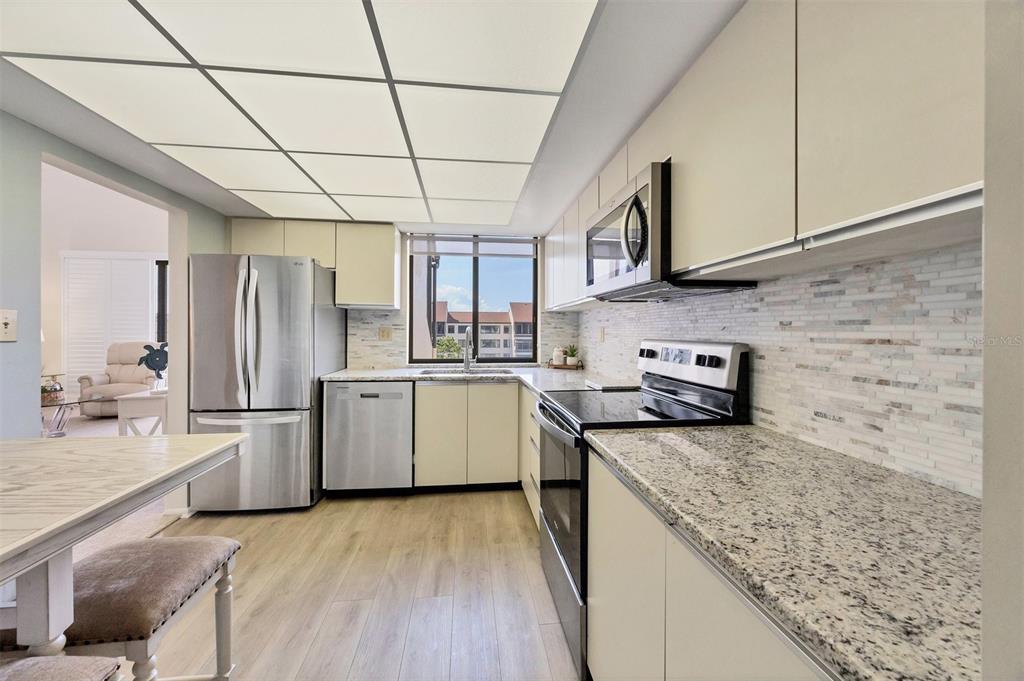 6285 Midnight Pass Road, Unit 403 Sarasota, FL 34242 - Photo 10 of 53 a kitchen with a sink stainless steel appliances and cabinets