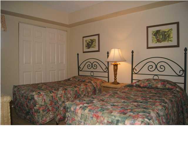 970 Highway 98, Unit 202 Destin, FL 32541 - Photo 14 of 26 a bedroom with a bed and a lamp on dresser
