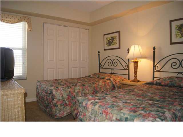 970 Highway 98, Unit 202 Destin, FL 32541 - Photo 15 of 26 a bedroom with a bed and a mirror
