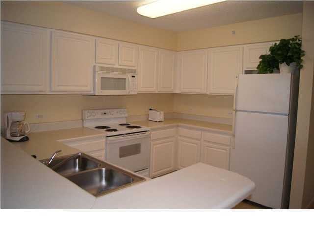 970 Highway 98, Unit 202 Destin, FL 32541 - Photo 9 of 26 a kitchen with white cabinets and white appliances