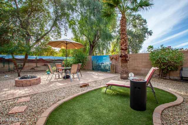 a view of a backyard with table and chairs under an umbrella