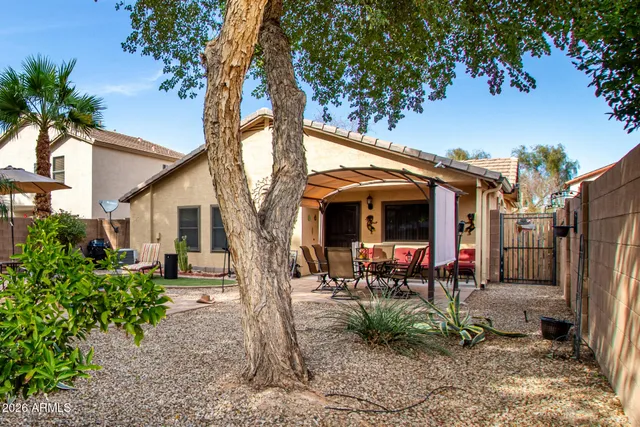 a view of a patio with table and chairs under an umbrella