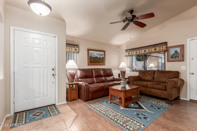 a living room with furniture a ceiling fan and a rug