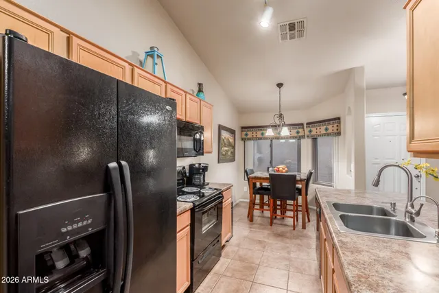 a kitchen with refrigerator and chairs