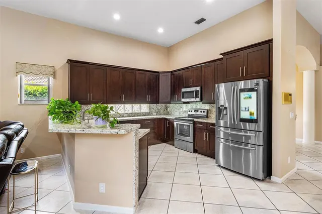 a kitchen with stainless steel appliances granite countertop a refrigerator sink and stove