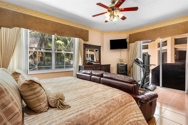 a bedroom with a bed couch and a large window