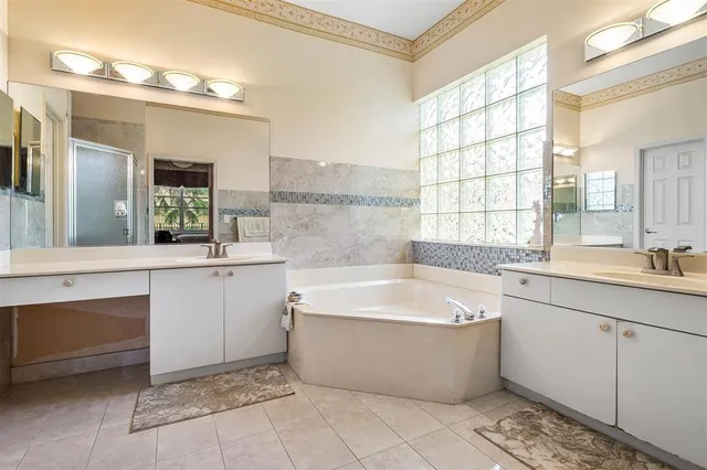 a large spacious bathroom with a large tub sink and mirror