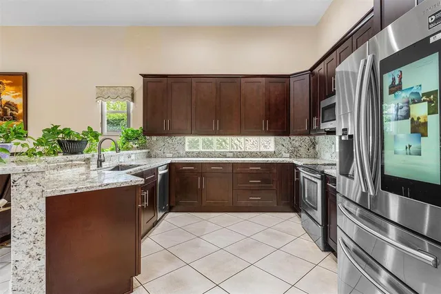 a kitchen with granite countertop a sink and a stove top oven