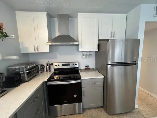 a kitchen with a refrigerator stove and cabinets