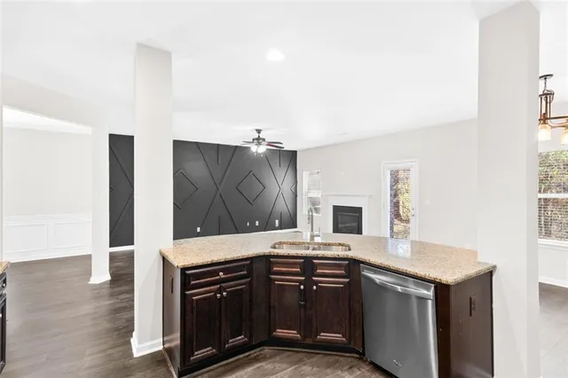 a kitchen with granite countertop a sink cabinets and stainless steel appliances
