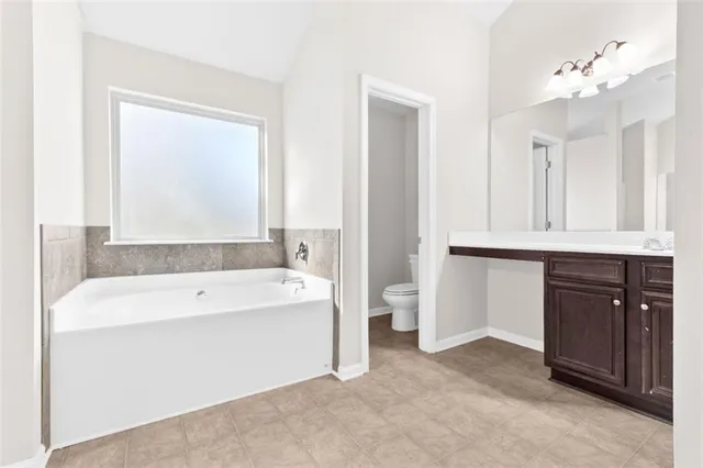 a bathroom with a tub a sink and a mirror
