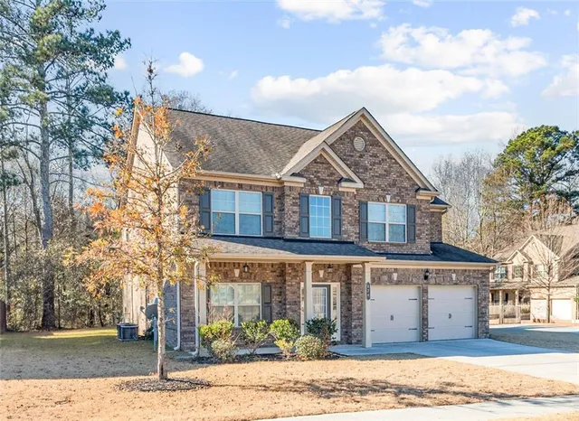a front view of a house with a garden and yard