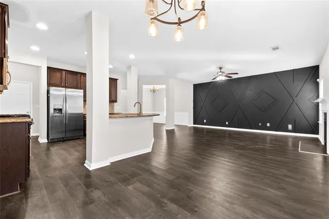 a view of a kitchen with a refrigerator and wooden floor
